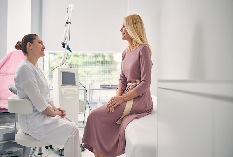 Cheerful blonde woman talking to her doctor
